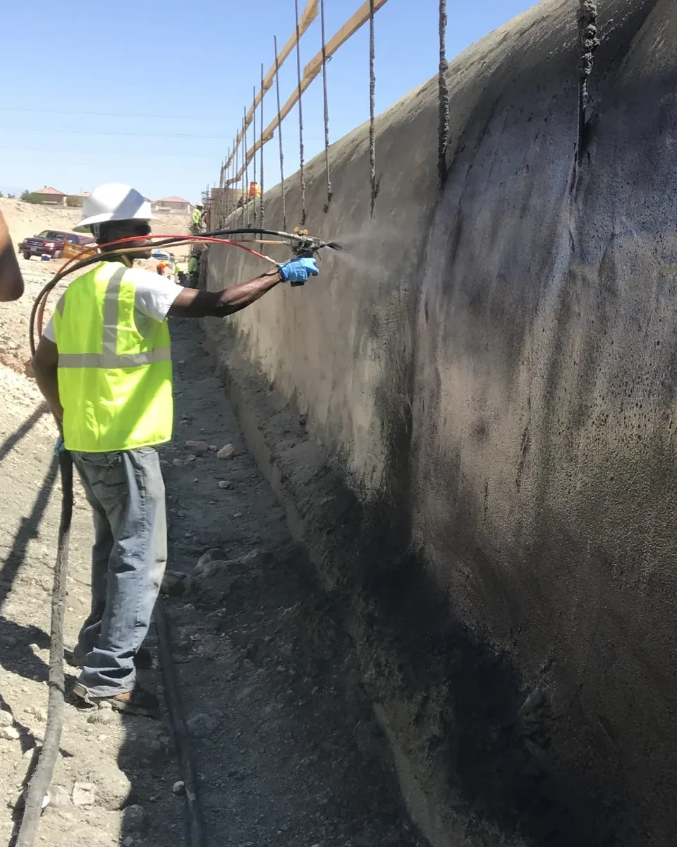 Operario aplicando WetSuit® por aspersión sobre un muro de contención